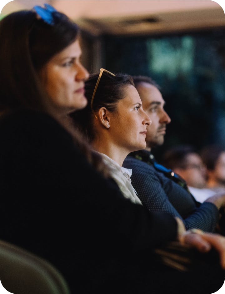 Three people listening to a lecture